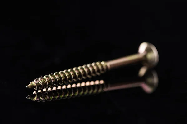 Close up view of shiny metal stud isolated on black — Stock Photo