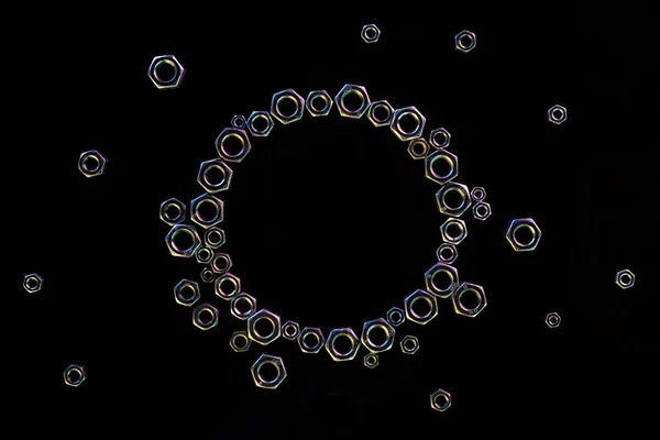 Vista dall'alto del cerchio di dadi metallici sparsi isolati su nero — Foto stock