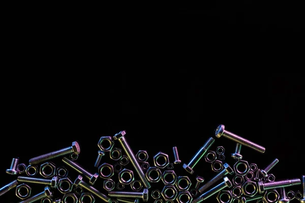 Vue de dessus de divers boulons et écrous dispersés isolés sur noir avec espace de copie — Photo de stock