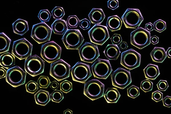 Vista superior de tuercas metálicas brillantes dispersas aisladas en negro - foto de stock