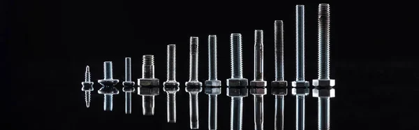 Panoramic shot of new shiny metallic bolts isolated on black — Stock Photo