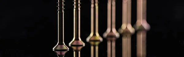 Panoramic shot of row of spotless metallic screws isolated on black — Stock Photo