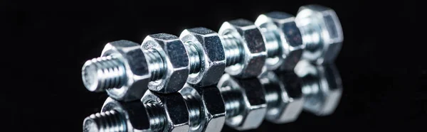 Panoramic shot of metal bolt with nuts isolated on black — Stock Photo