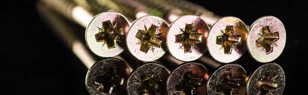 Panoramic shot of shiny heads of metal studs isolated on black — Stock Photo