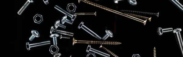 Panoramic shot of scattered nuts, bolts and studs isolated on black — Stock Photo