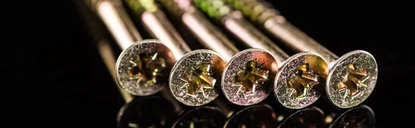 Panoramic shot of heads of metal studs isolated on black — Stock Photo