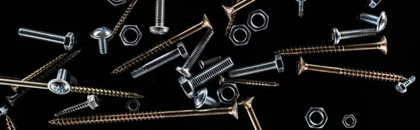 Panoramic shot of scattered screws isolated on black — Stock Photo