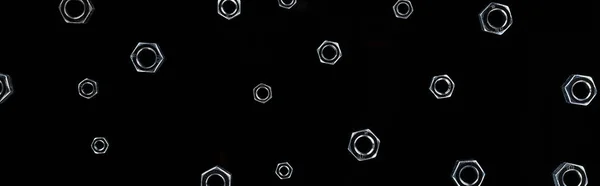 Panoramic shot of scattered metal nuts pattern isolated on black — Stock Photo