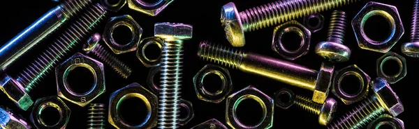 Panoramic shot of scattered steel nuts and bolts isolated on black — Stock Photo