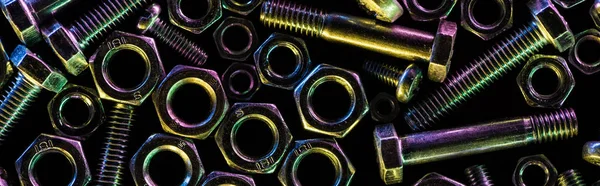Panoramic shot of scattered metallic bolts and nuts isolated on black — Stock Photo