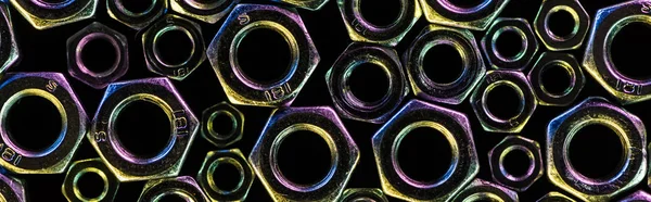 Tiro panorâmico de várias nozes metálicas espalhadas isoladas em preto — Fotografia de Stock