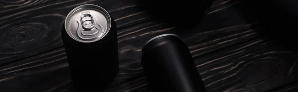 Панорамный снимок черных банок пива на деревянном столе с копировальным местом — стоковое фото