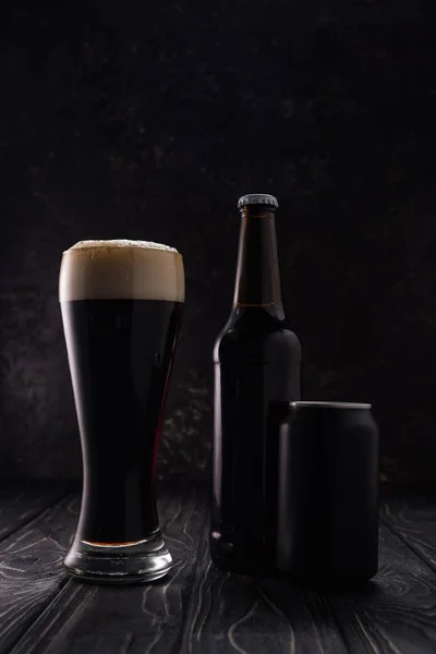 Bottle, can and glass of beer on wooden table — Stock Photo