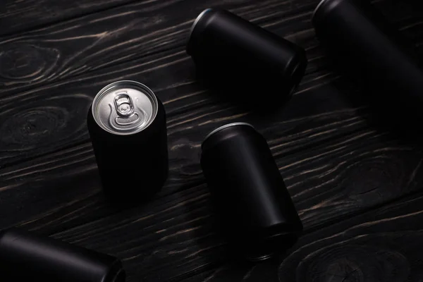 Latas de alumínio preto de cerveja na mesa de madeira — Fotografia de Stock