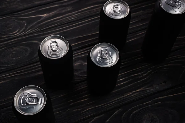 Boîtes métalliques noires de bière sur table en bois — Photo de stock