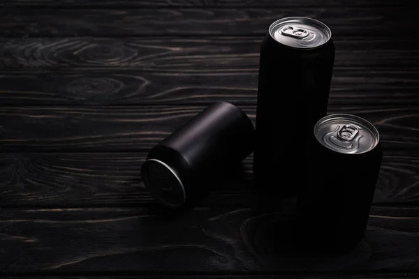 Black cans of beer on wooden table with copy space — Stock Photo