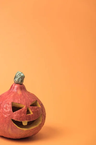 Spooky Halloween pumpkin on orange background — Stock Photo