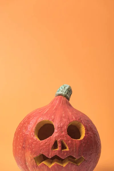 Espeluznante calabaza de Halloween sobre fondo naranja - foto de stock