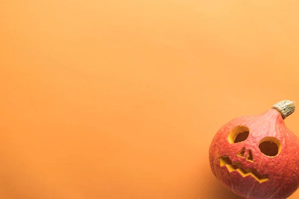 Vista superior da abóbora de Halloween esculpida no fundo laranja — Fotografia de Stock