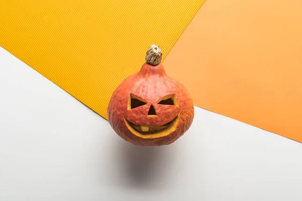 Vista superior de la calabaza de Halloween sobre fondo blanco y naranja - foto de stock