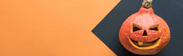 Plano panorámico de calabaza de Halloween sobre fondo negro y naranja - foto de stock