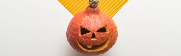 Panoramic shot of scary Halloween pumpkin on white and orange background — Stock Photo