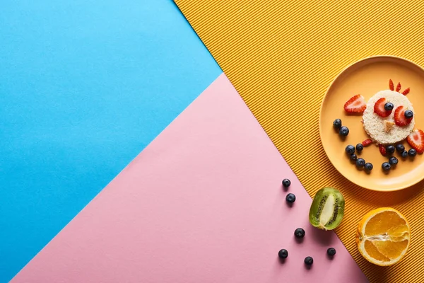 Vista superior da placa com animal de fantasia feito de alimentos para crianças café da manhã em fundo azul, amarelo e rosa — Fotografia de Stock