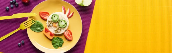 Top view of plate with fancy cow made of food with cutlery on purple and orange background, panoramic shot — Stock Photo