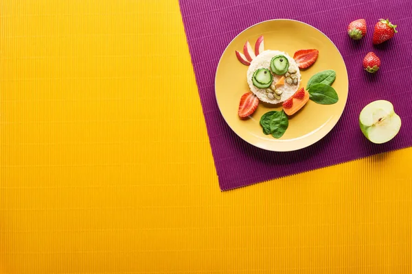 Vista dall'alto del piatto con mucca fantasia fatta di cibo su sfondo viola e arancione — Foto stock