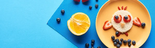 Vista dall'alto del piatto con animale fantasia fatto di cibo su sfondo blu con frutta, colpo panoramico — Foto stock