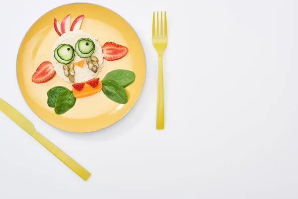 Vista superior da placa com animal de fantasia feito de alimentos para crianças café da manhã perto de talheres no fundo branco — Fotografia de Stock