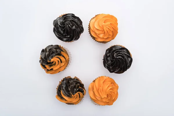 Vista superior de deliciosos cupcakes de Halloween en círculo aislado en blanco - foto de stock
