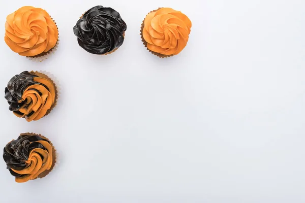 Flat lay with delicious Halloween cupcakes on white background with copy space — Stock Photo