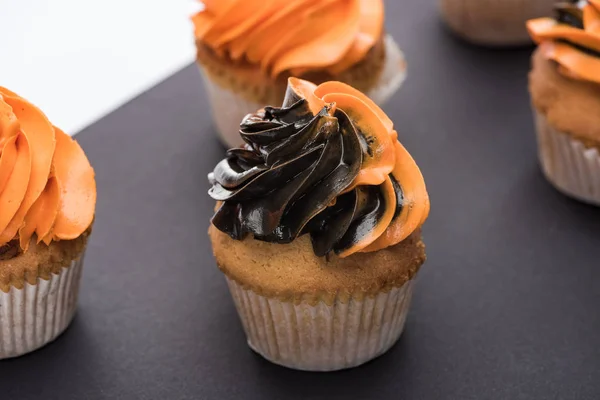 Вкусные кексы на Хэллоуин с черным и оранжевым кремом — стоковое фото