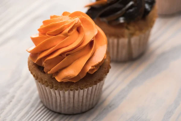 Foco seletivo de delicioso cupcake de laranja de Halloween na mesa de madeira — Fotografia de Stock