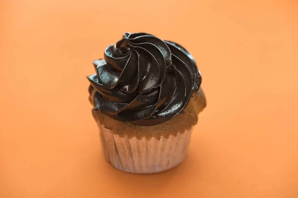 Negro delicioso pastel de Halloween sobre fondo naranja - foto de stock