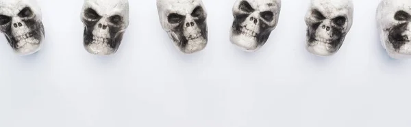 Vista superior de crânios decorativos sobre fundo branco com espaço de cópia, tiro panorâmico — Fotografia de Stock