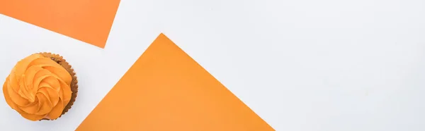 Draufsicht auf köstlichen Halloween-Cupcake auf orangefarbenem und weißem Hintergrund mit Kopierraum, Panoramaaufnahme — Stockfoto