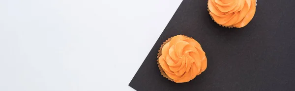 Vista dall'alto di deliziosi cupcake di Halloween su sfondo bianco e nero con spazio copia, scatto panoramico — Foto stock