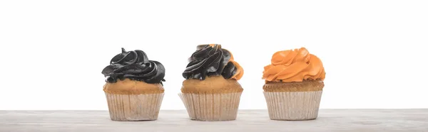 Delicious Halloween orange and black cupcakes isolated on white, panoramic shot — Stock Photo