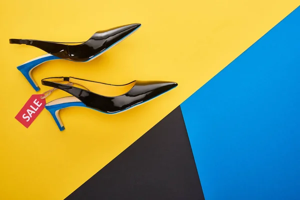 Вид зверху взуття з торговою маркою на синьому, жовтому та чорному тлі — стокове фото