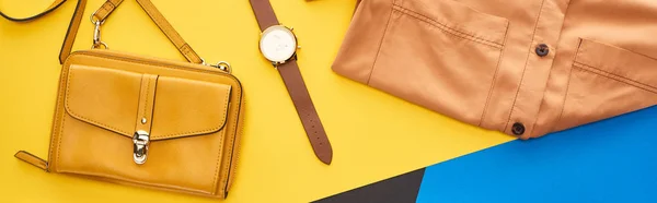 Top view of shirt and accessories on blue, yellow and black background — Stock Photo