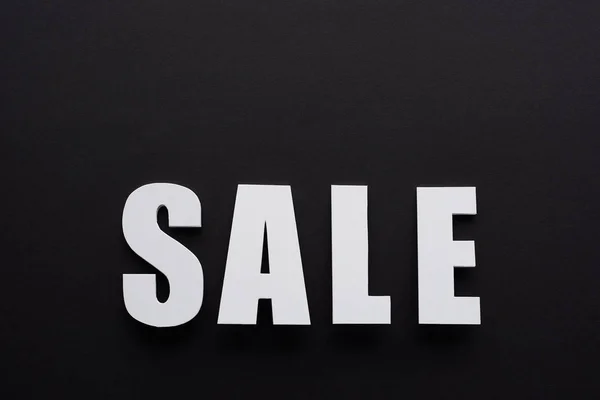 Top view of white sale lettering on black background — Stock Photo