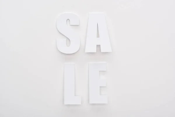 Vista superior de lettering venda branca no fundo branco — Fotografia de Stock