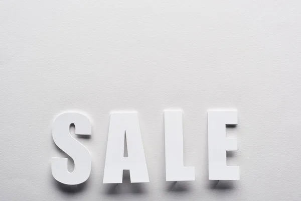 Top view of white sale lettering on white background — Stock Photo