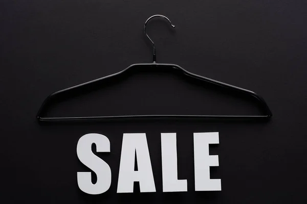 Vista dall'alto di vendita bianco lettering con appendiabiti su sfondo nero — Foto stock