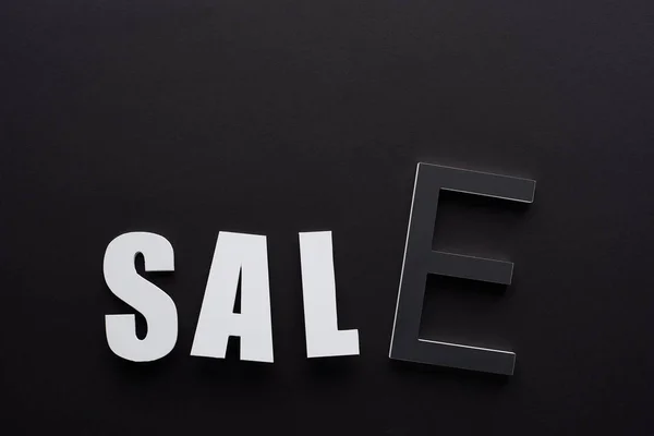 Vista superior de la venta de letras sobre fondo negro - foto de stock