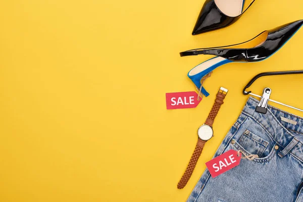 Draufsicht auf modische Kleidung mit Verkaufsetikett auf gelbem Hintergrund — Stockfoto