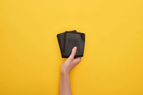 Cropped view of woman holding wallet on yellow background — Stock Photo