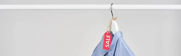 Chemise bleue suspendue avec étiquette de vente isolée sur blanc, vue panoramique — Photo de stock